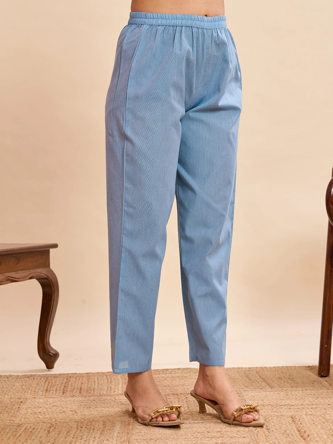 Light blue pants worn by a person on a beige background